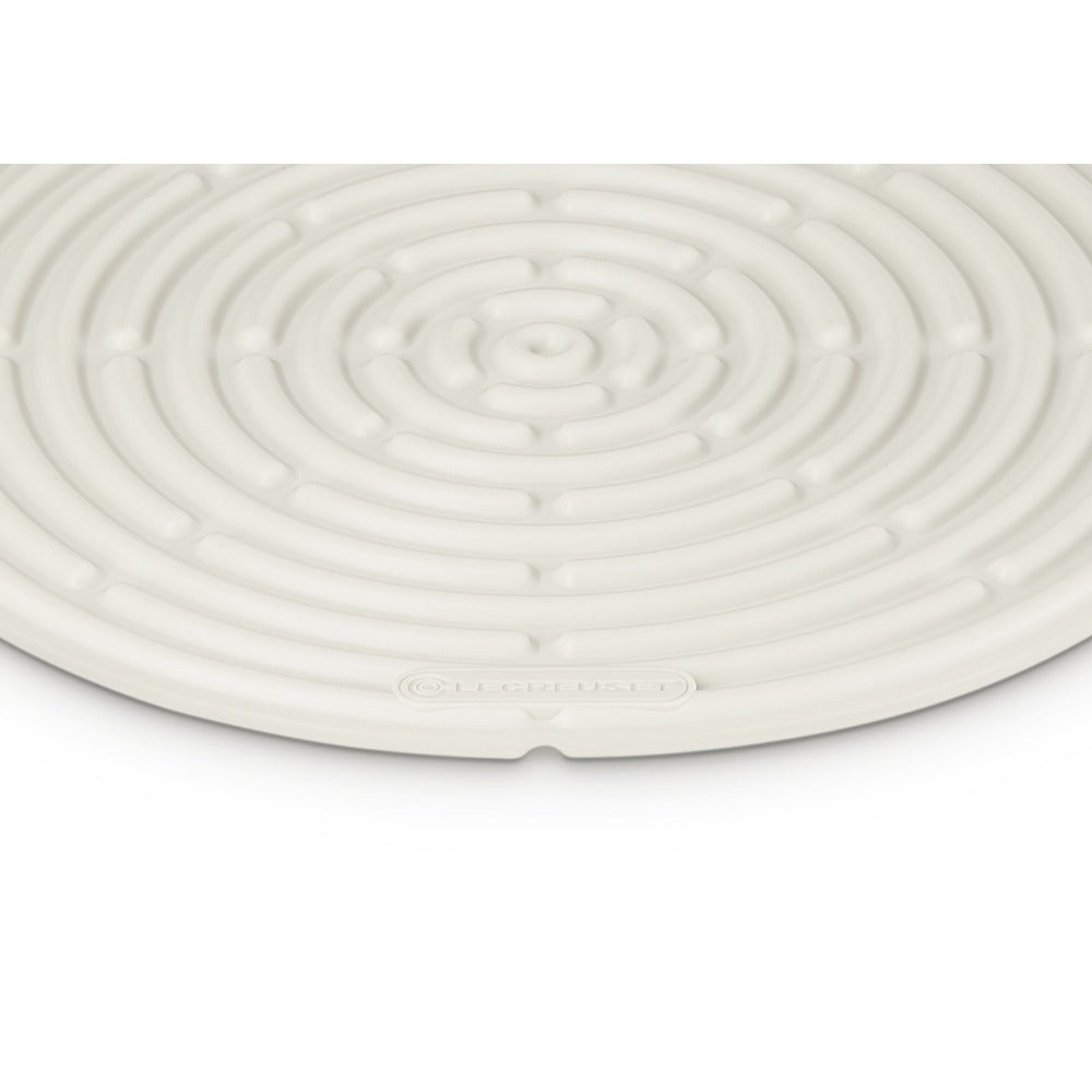 Tapis en silicone blanc à surface spiralée et logo “LE CREUSET” visible.