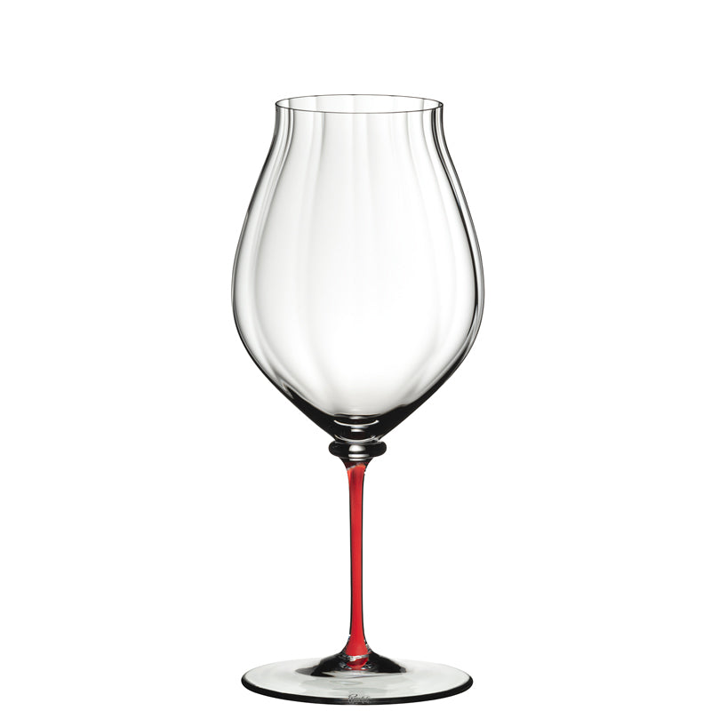 Calice à vin transparent avec pied fin de couleur rouge, sur fond blanc.