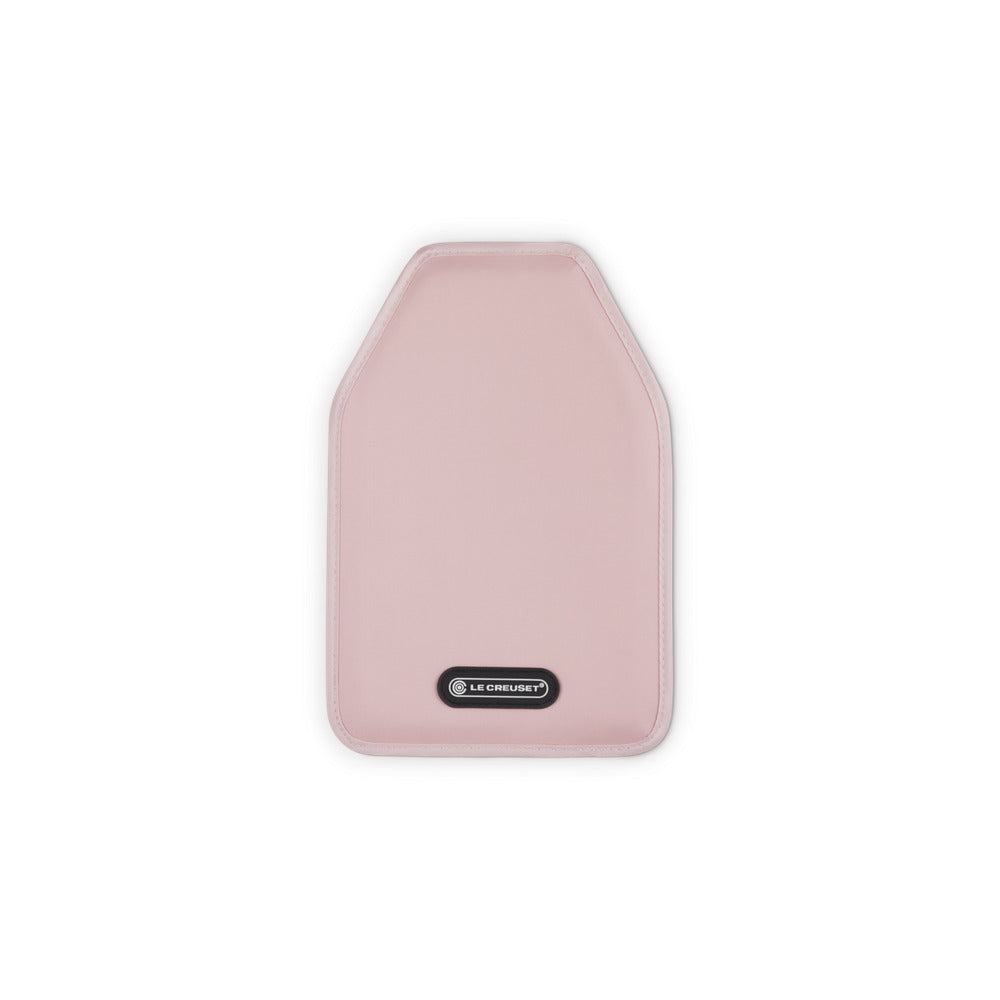 Sottopentola rosa con forma rettangolare arrotondata, in materiale morbido, con logo "LE CREUSET" in nero.
