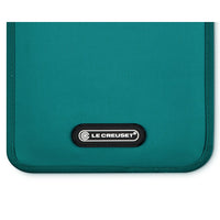 Teal fabric bag with black label with "LE CREUSET" text.