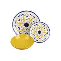 Due piatti decorati con motivi blu e gialli e una ciotola gialla in ceramica, su sfondo bianco.