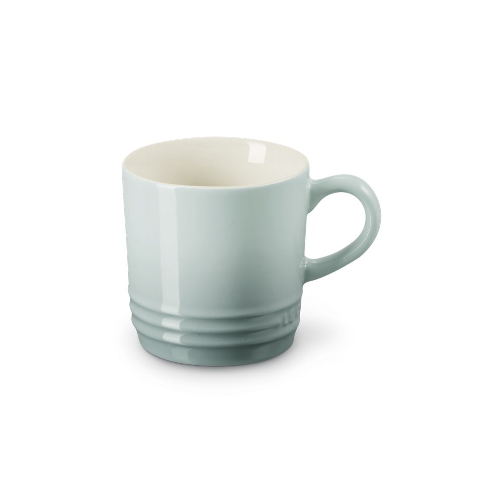 Tazza di ceramica azzurro chiaro, con manico e base leggermente rigate, superficie liscia e interna bianca.
