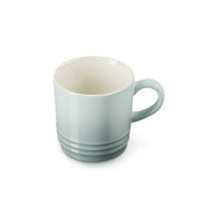 Tazza di ceramica di colore azzurro chiaro con interno bianco e manico, presenta scanalature orizzontali sulla base.