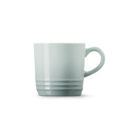 Tazza di ceramica dallo stile semplice e moderno, di colore azzurro chiaro con manico e scanalature nel design.