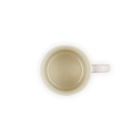 Tazza rotonda, beige con manico rosa, vista dall'alto, con interno liscio e brillante.