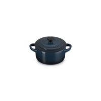 Enamelled cast iron casserole in dark blue, round, with lid and handles. decorated with the logo "Le Creuset".