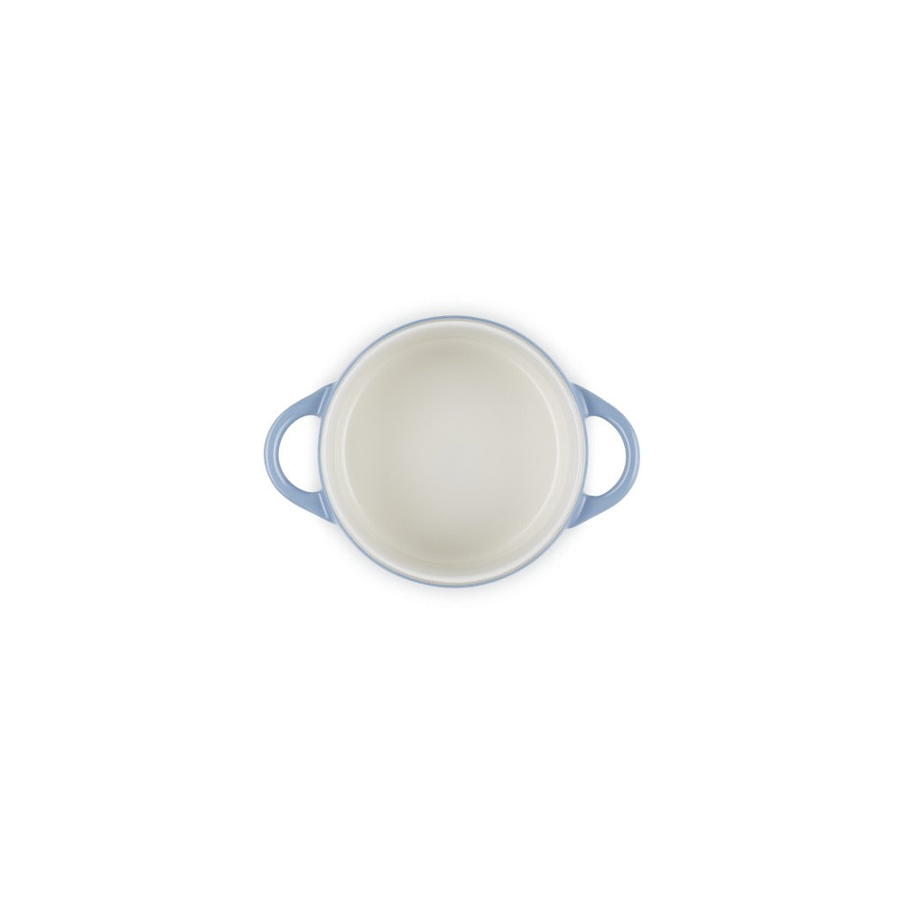 Round casserole with handles blue, interiormente white, on light background and uniforme.