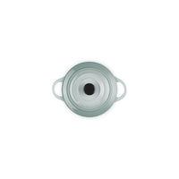 Mint-colored ceramic lid with side grips and central hole, glossy surface and refined details.