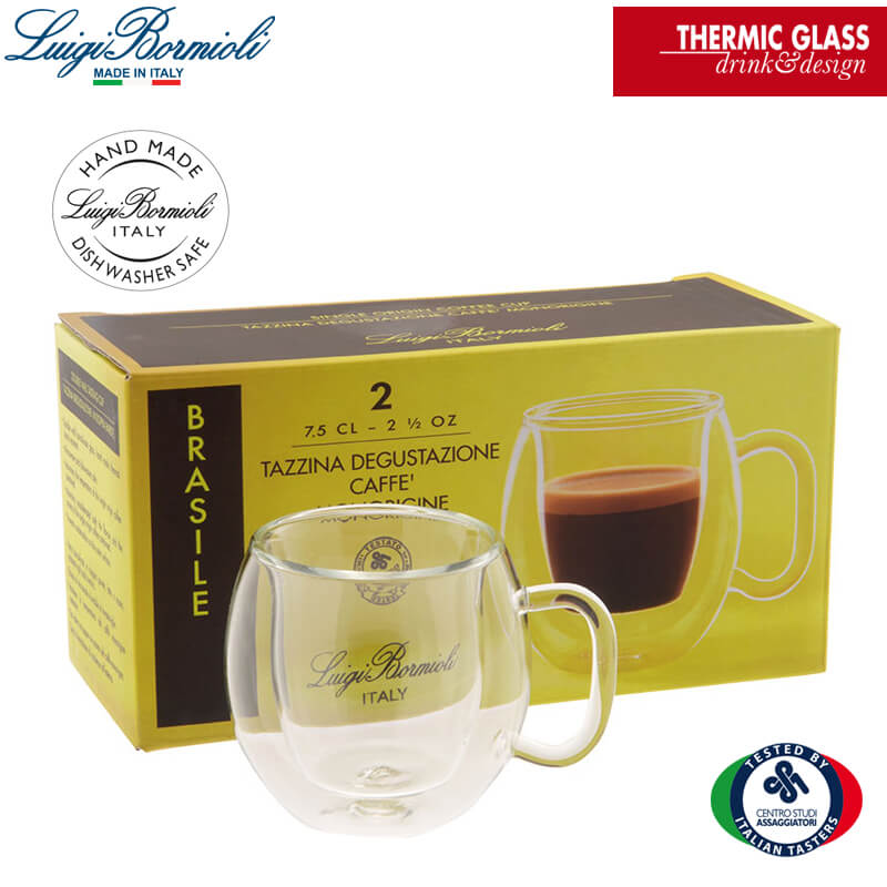 Transparent double-wall espresso cup with glass handle in front of yellow box with cup design and text in
