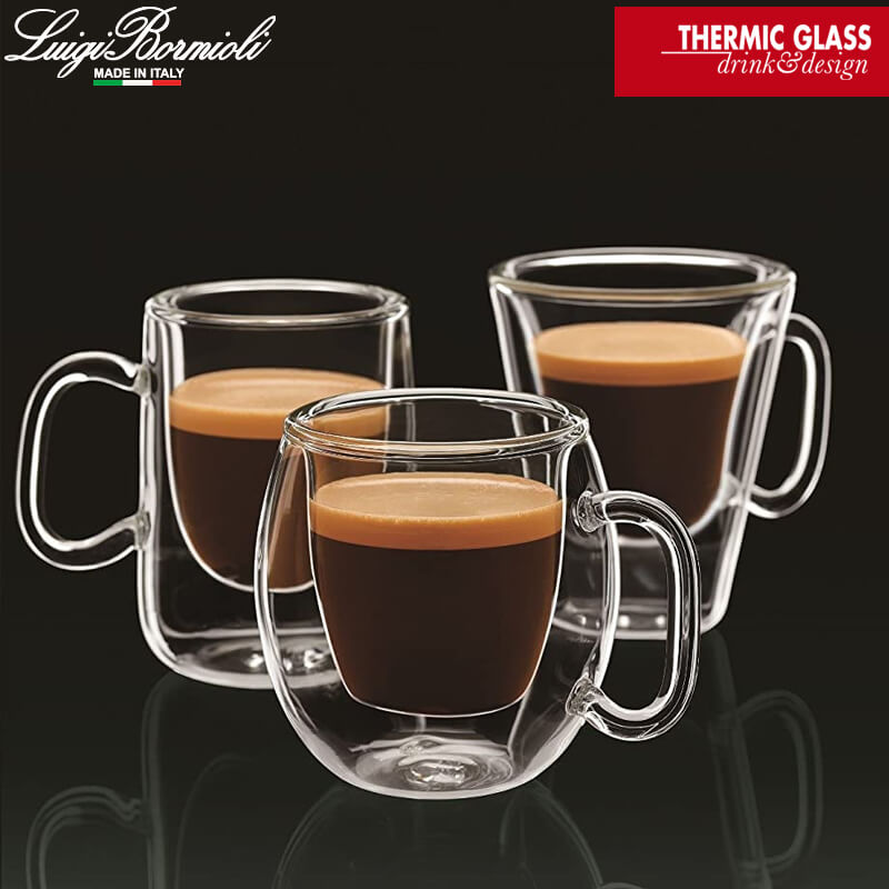 Three transparent double-wall glass cups containing coffee with foam on black background