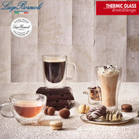 dos tazas de vidrio transparente con café y cappuccino, dulces y macarons sobre superficie clara
