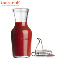 Transparante glazen container met rode saus en losse metalen sluiting, Lock-eat-logo gegraveerd op de