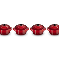 Set di quattro cocotte rotonde rosse con manici e coperchio nero, su sfondo bianco.