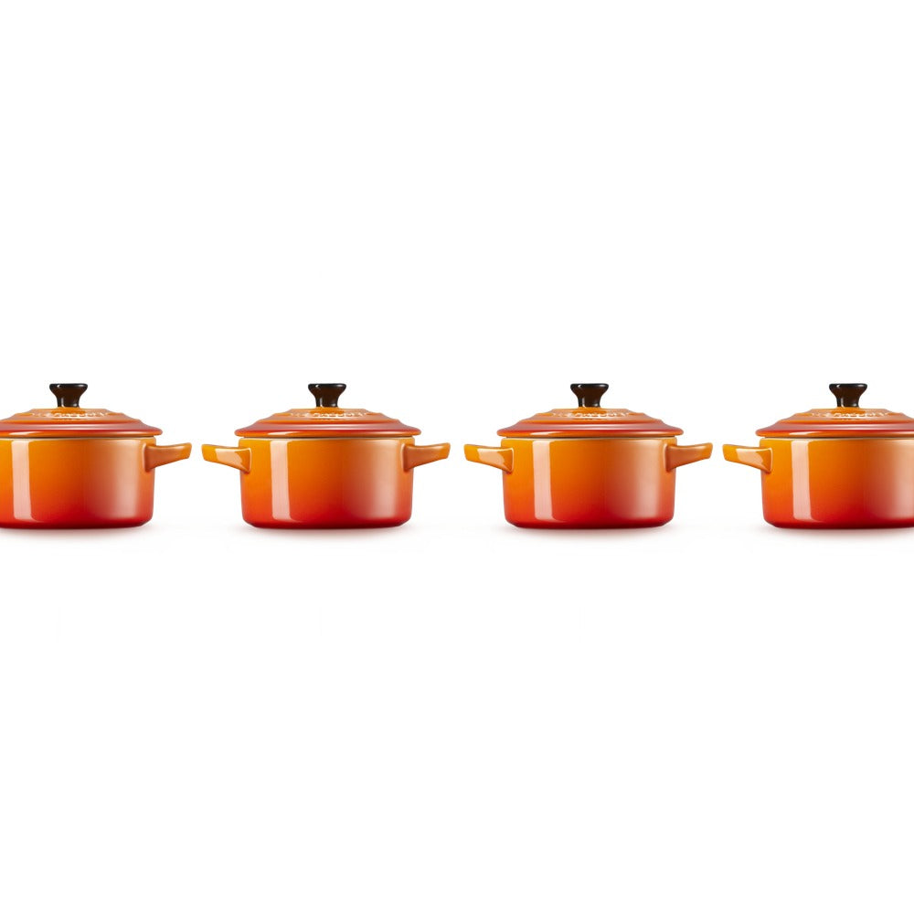 Deux casseroles orange avec poignées, forme cylindrique et couvercle, disposées en rangée sur fond blanc.