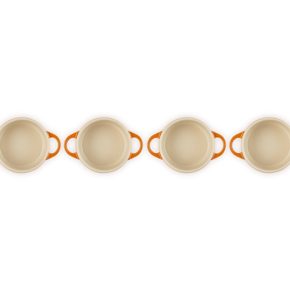 Set de casseroles avec poignées orange, forme ronde et couleur blanche, disposées en rangée sur fond blanc.