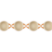 Set de casseroles avec poignées orange, forme ronde et couleur blanche, disposées en rangée sur fond blanc.