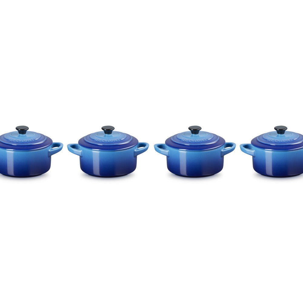 Casseroles en céramique bleue, de différentes tailles, avec couvercles et anses, sur fond blanc.