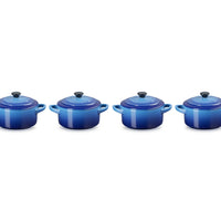 Casseroles en céramique bleue, de différentes tailles, avec couvercles et anses, sur fond blanc.
