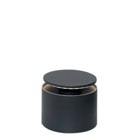 Grey metal cylindrical table lamp with slightly raised round shade, neutral white setting