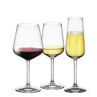 Tre bicchieri di vetro trasparente con diverse bevande: rosso, bianco e spumante, su sfondo bianco.