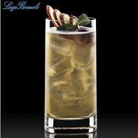 Grand verre transparent avec boisson jaune, glace et garniture de tranches de pomme, raisin et feuille de menthe
