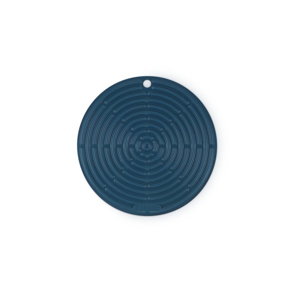 Tapis circulaire en silicone bleu foncé à dessin spiralé, avec un trou pour accrocher.