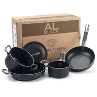 Set di quattro pentole nere con manici in metallo e silicone, con coperchio, davanti a una scatola in cartone marrone con scritte.