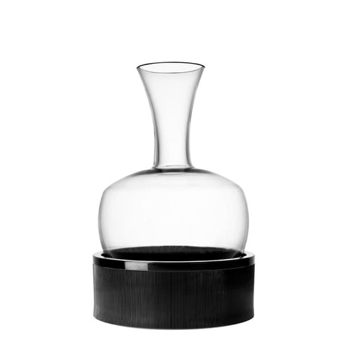 Transparent glass decanter with textured black cylindrical base, on neutral white background.