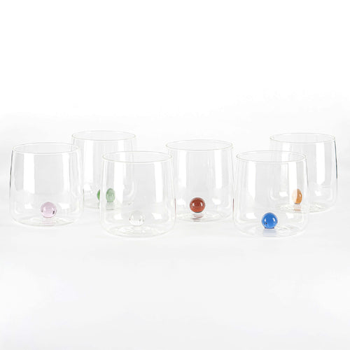 Sei bicchieri trasparenti in vetro con base rotonda colorata nelle tonalità rosa, verde, chiaro, rosso, blu e arancione, su sfondo bianco.
