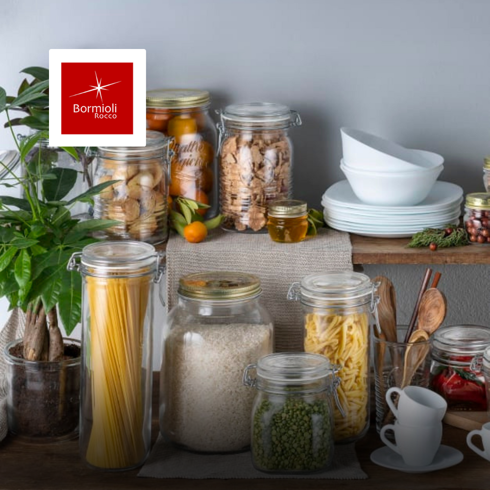 barattoli di vetro trasparente con coperchio contenenti pasta, riso, biscotti, legumi su tavolo di legno con