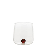 Transparant glas met afgeronde bodem en rand en donkerrode decoratieve bol op de bodem, neutrale witte achtergrond