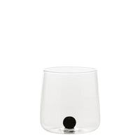 Transparant glas met afgeronde bodem en zwarte bol op de bodem, neutrale witte achtergrond