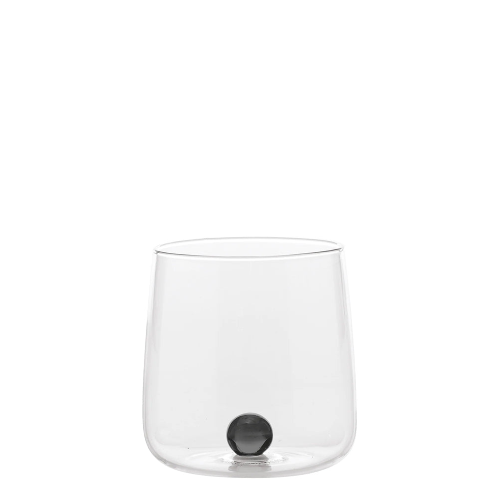 Transparant glas met ronde bodem, kleine glanzende zwarte bol erin, neutrale witte achtergrond.