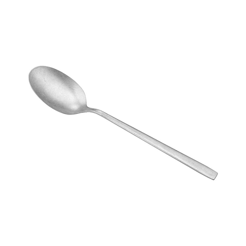 Cucchiaio in acciaio inox, forma ovale con manico lungo e sottile, finitura opaca. Sfondo bianco.