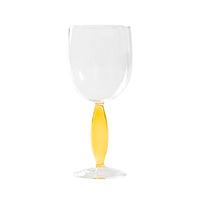 Vaso transparente con tallo alargado coloreado en amarillo sobre fondo blanco