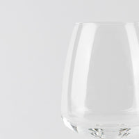 Vaso transparente de cristal con forma redondeada sobre fondo blanco uniforme