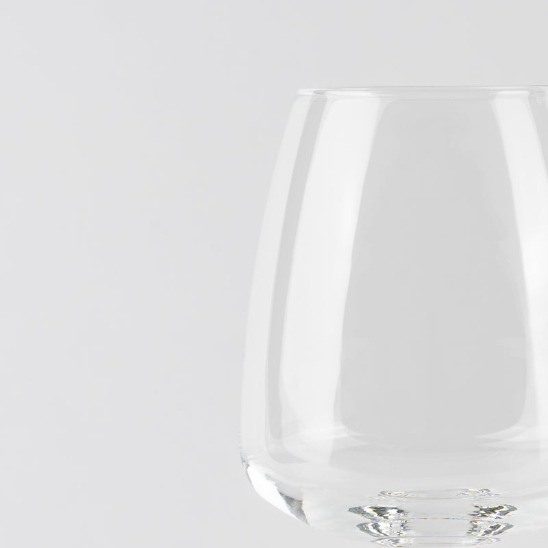 Vaso transparente de cristal con forma redondeada sobre fondo blanco uniforme