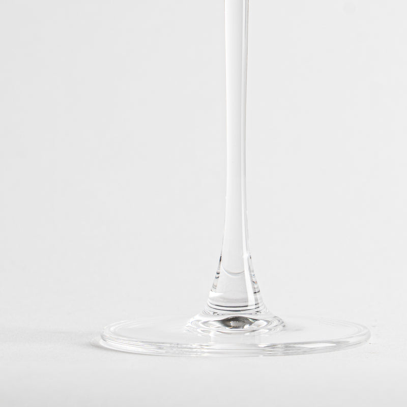 base et tige fines et transparentes d'un calice en verre sur fond blanc