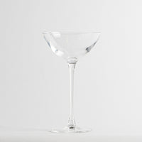 Verre transparent en verre en forme de coupe avec base ronde sur fond blanc