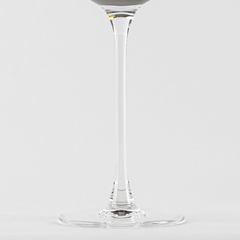Verre transparent en verre avec tige fine et base ronde sur fond blanc uniforme