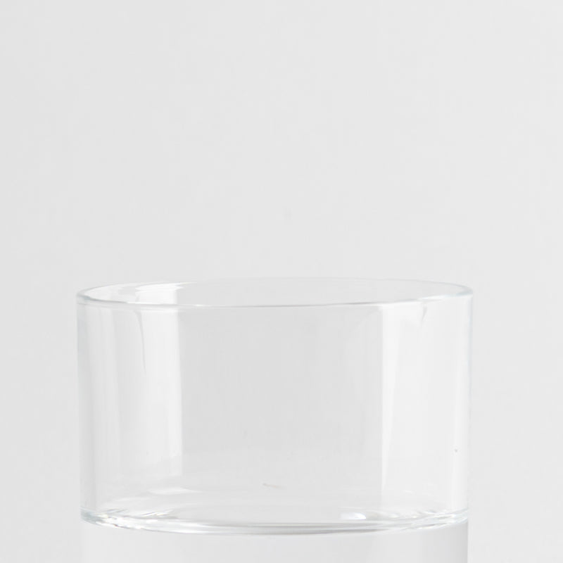 Verre transparent en verre avec forme cylindrique sur fond blanc uniforme