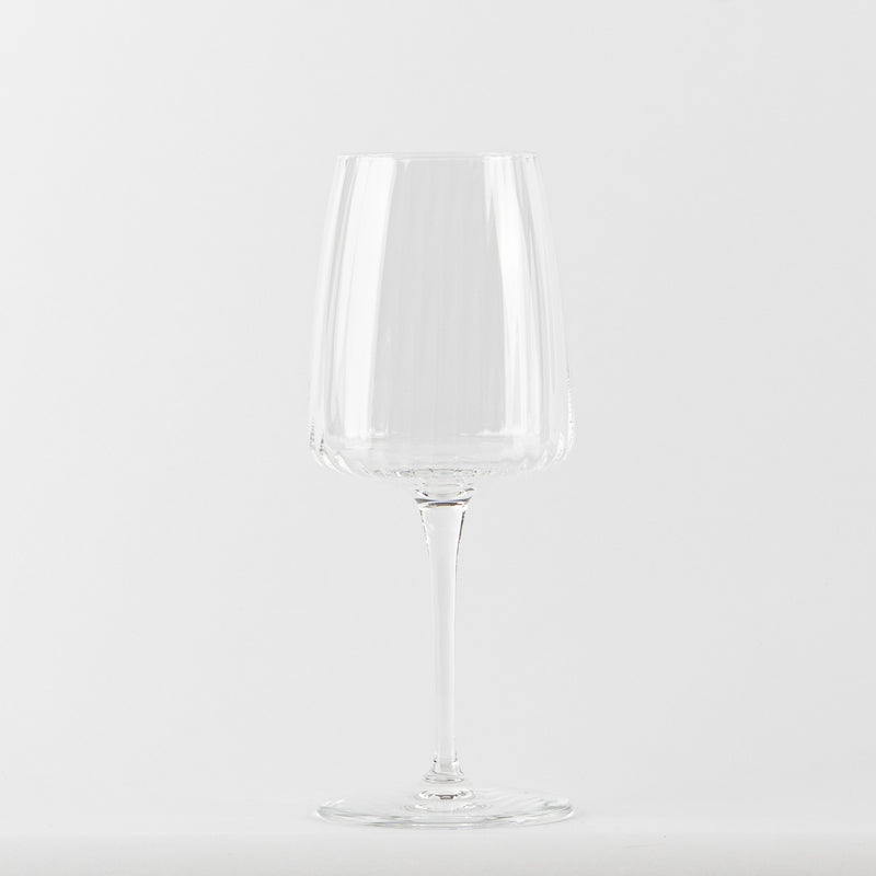Transparent glass wine glass with conical bowl on thin stem and circular base, white background.