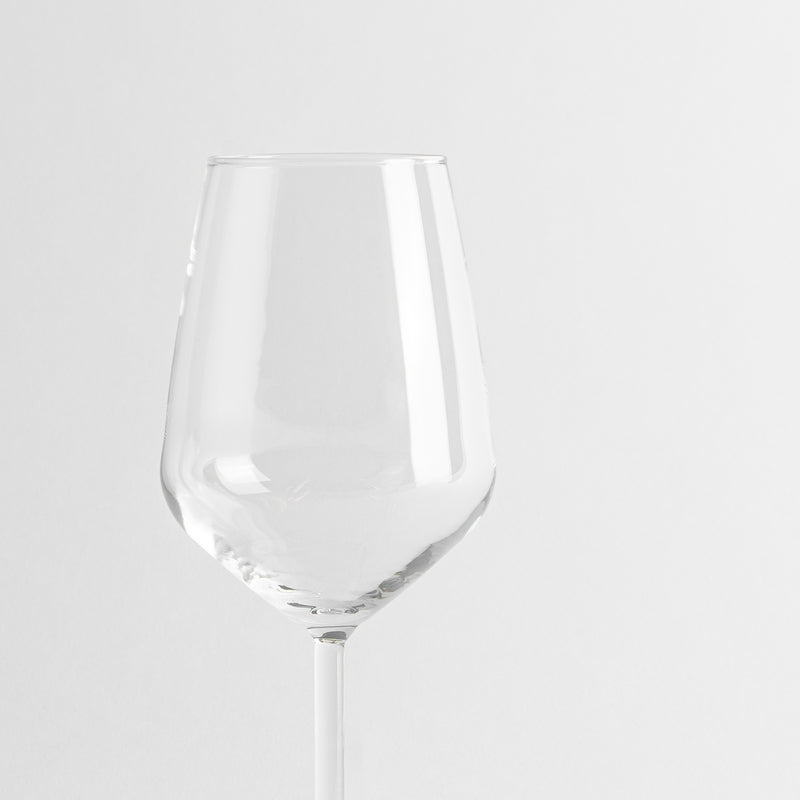 Transparent glass wine glass with thin stem on uniform white background.