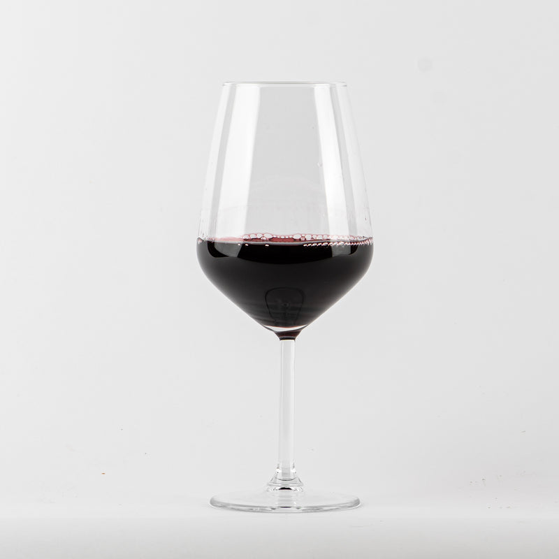 transparent stemmed glass in glass with red wine scuro on white background