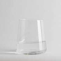 Transparante glazen beker met acqua half full op neutral light background