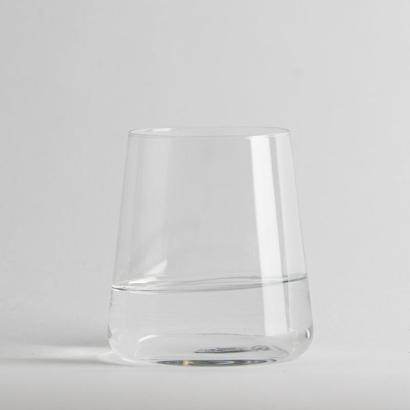 Transparante glazen beker met acqua half full op neutral light background