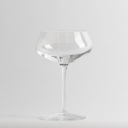 Transparentes Glas-Weinglas mit dünnem Stiel und breiter flacher Schale auf weißem Hintergrund