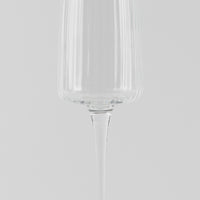 Verre à vin en verre transparent à structure à rainures verticales sur fond gris clair.