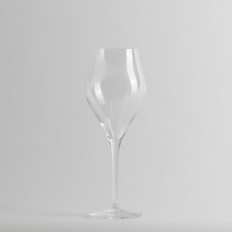 Transparent glass with sinuous shape and thin stem on light grey background