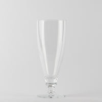 Transparent glass wine glass with elongated shape, stem and round base on white background